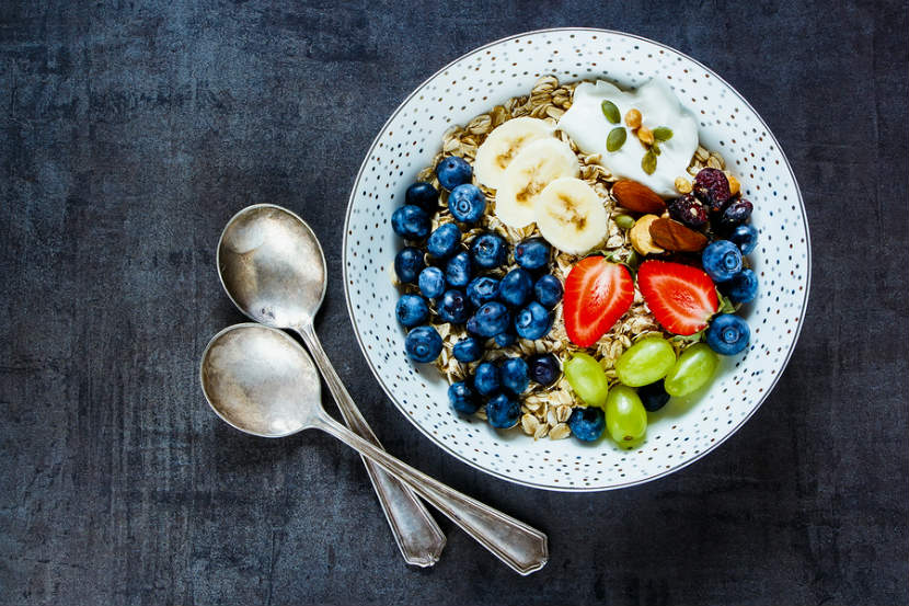 bowl of dry oats with fruit, seeds and yogurt on top