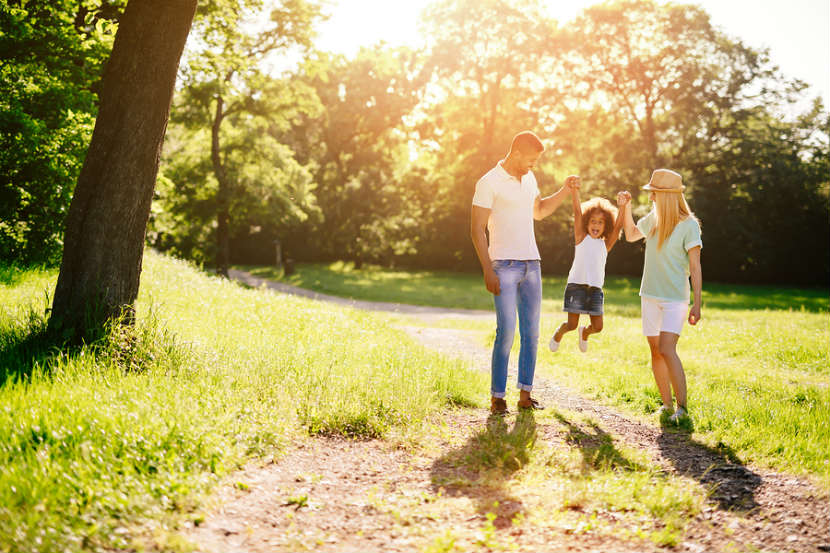 mother and father taking a walk with their daughter