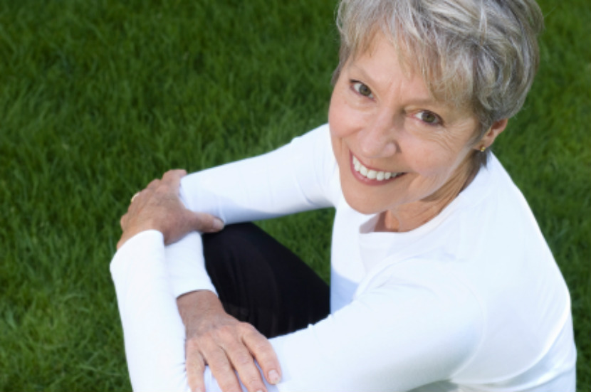 happy senior woman sitting on grass