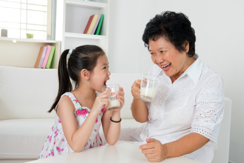 grandmother sitting down and having a drink with her grandaughter