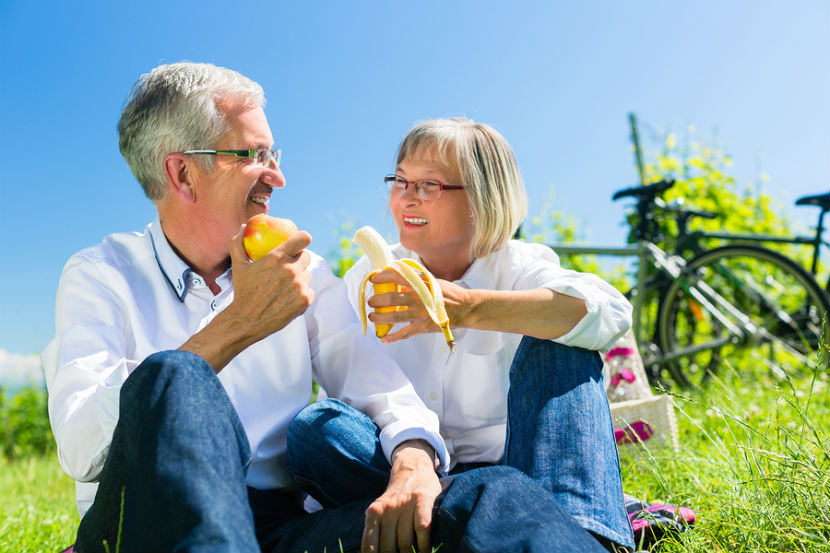 man and a woman eating fruit