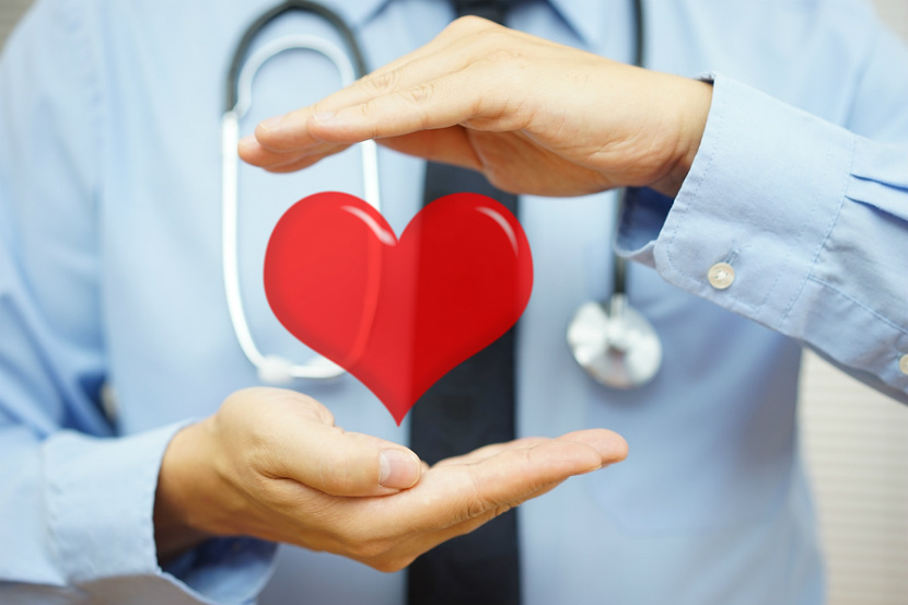 doctor with a stethoscope holding a heart