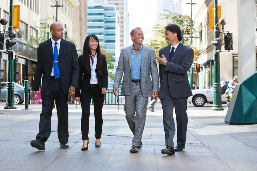 men and women walking in business suits