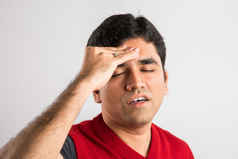 man holding his head because of a headache