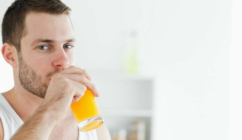 young man drinking orange juice