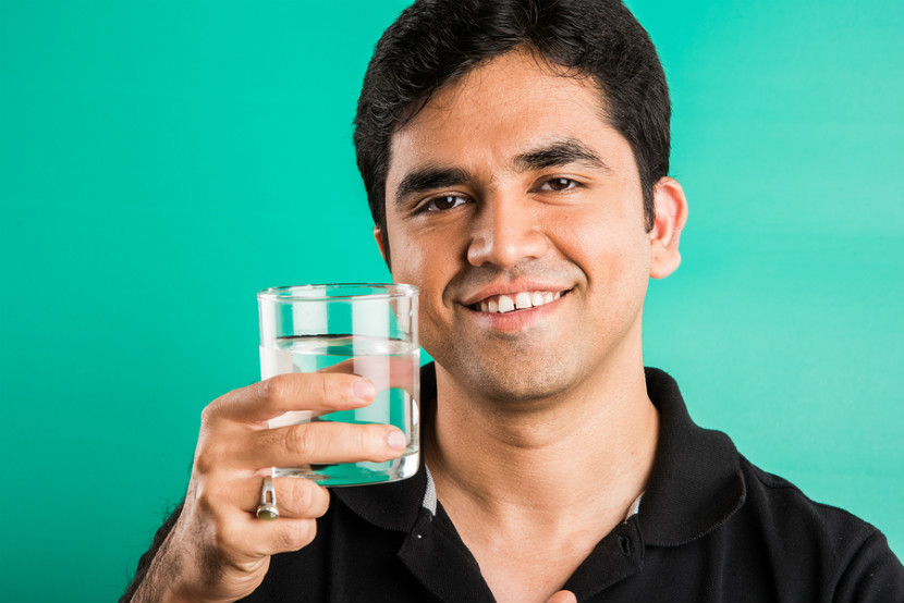 man drinking a glass of water